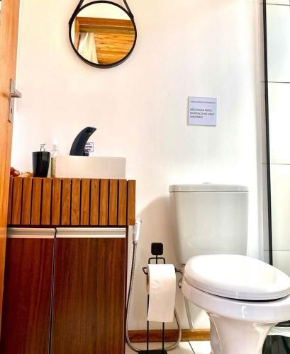 a bathroom with a white toilet and a mirror at Tiny Urubici -P Cachoeira da Neve in Urubici