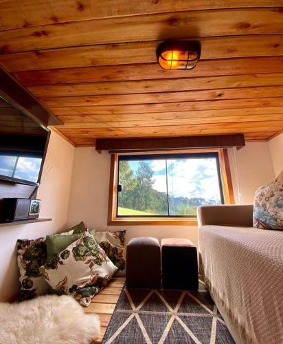 a living room with a bed and a window at Tiny Urubici -P Cachoeira da Neve in Urubici