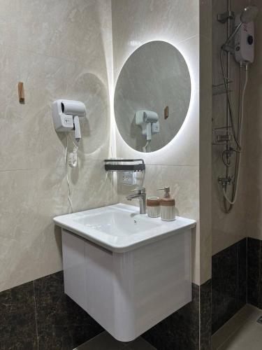 a bathroom with a white sink and a mirror at Boho Apartment in Mai Khao Beach