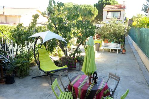 a patio with a table and chairs and an umbrella at Pavillon Clara Flor in Prades