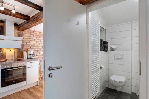 a bathroom with a toilet and a glass shower door at Erlebnis-Bauernhof Heimatliebe in Oberkirch