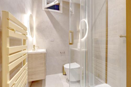 une salle de bain avec toilettes et douche en verre dans l'établissement Studio luxueux a Paris with AC a proximite du Marais, à Paris