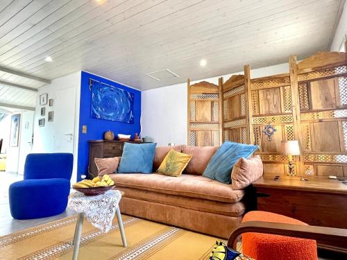 - un salon avec un canapé brun et des murs bleus dans l'établissement La Méridienne - Calm - Cosy, à Le Poiroux