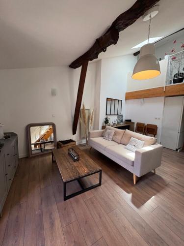 a living room with a white couch and a table at "Le Dix", emplacement exceptionnel, parking inclus in Montauban