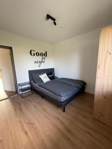 a bed in a room with a sign on the wall at Ferienwohnung AusZeit 1 in Ainring
