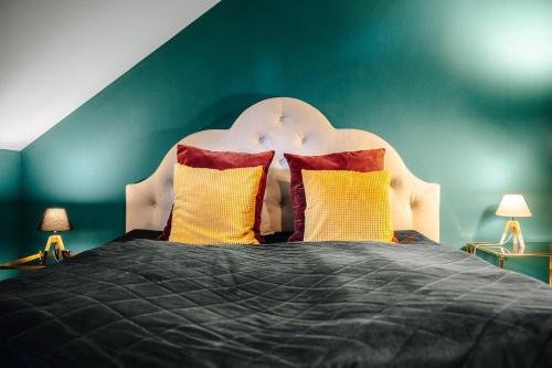 a bedroom with a large bed with colorful pillows at WagnerStays BadEms Historic VillaWhirpool Billiard in Bad Ems