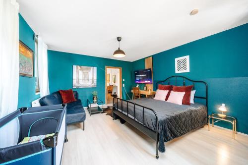 a bedroom with blue walls and a bed and a couch at WagnerStays BadEms Historic VillaWhirpool Billiard in Bad Ems