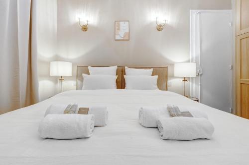 - une chambre avec un lit blanc et 2 serviettes dans l'établissement Appartment haut de gamme en plein coeur de Paris, à Paris