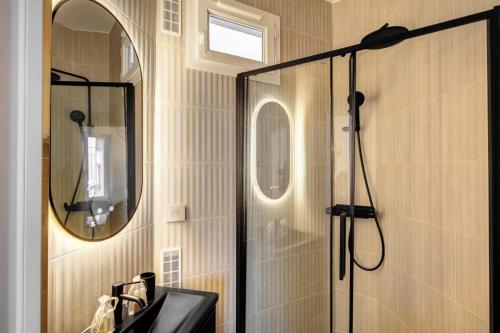 une salle de bain avec une douche avec un lavabo et un miroir dans l'établissement Appartment haut de gamme en plein coeur de Paris, à Paris