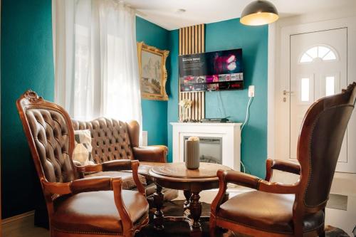 a living room with two chairs and a table and a candle at WagnerStays BadEms Historic VillaWhirpool Billiard in Bad Ems