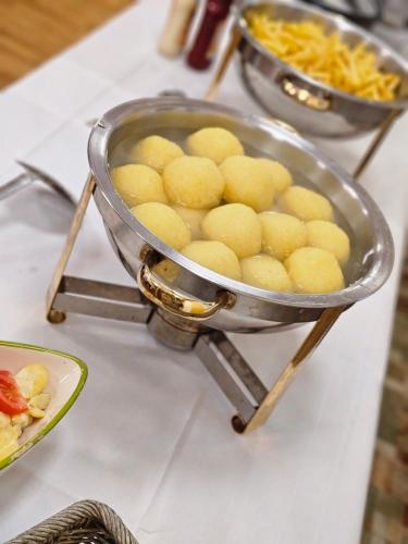 a metal bowl of food on a counter with other foods at Gasthof goldener Engel in Kemnath