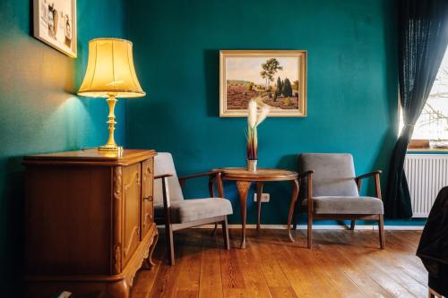 a room with a table and two chairs and a lamp at WagnerStays BadEms Historic VillaWhirpool Billiard in Bad Ems