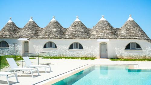 a villa with a swimming pool in front of a building at Masseria Surace in Noci