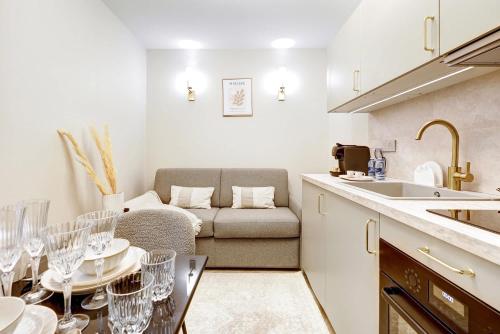 une cuisine avec un canapé et une table avec des verres à vin dans l'établissement Charming studio with A-C, à Paris