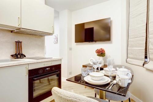 une cuisine avec une table avec des assiettes et des verres à vin dans l'établissement Charming studio with A-C, à Paris
