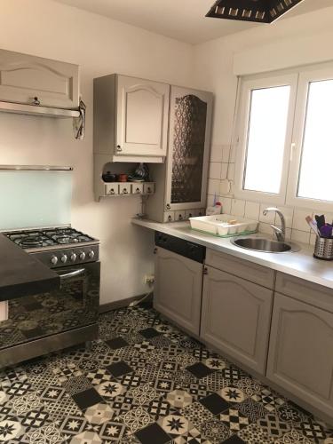 une cuisine avec un évier et une cuisinière dans l'établissement Duplex, à La Celle-sous-Gouzon