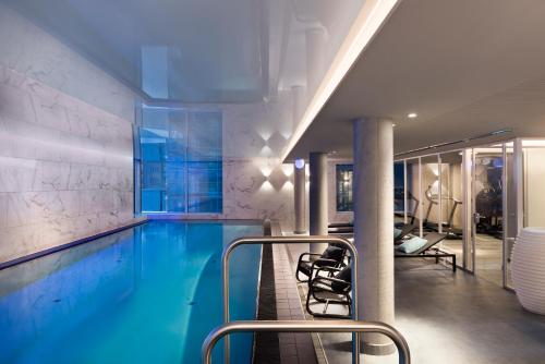 a swimming pool in a hotel room with a gym at Adina Apartment Hotel Hamburg Speicherstadt in Hamburg