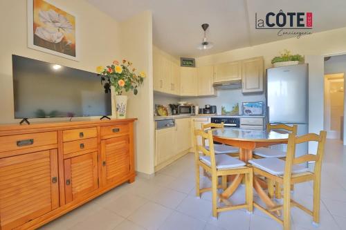 une cuisine avec une table, des chaises et un réfrigérateur dans l'établissement La Nonna, à Carry-le-Rouet