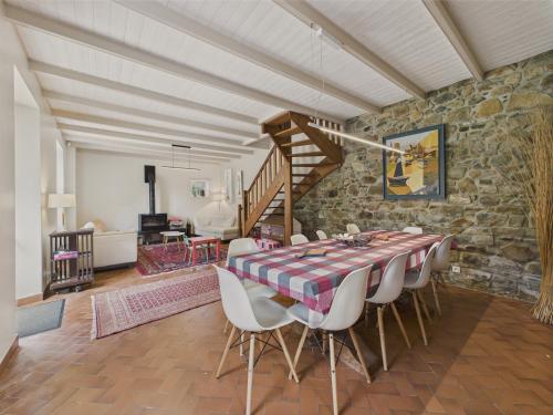 une salle à manger avec une table et des chaises et un mur en pierre dans l'établissement Idéal 8 adultes et 5 enfants - 200m plage, à Plougrescant