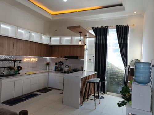 a kitchen with white cabinets and a counter top at Teras Senja Sikunir in Kejajar