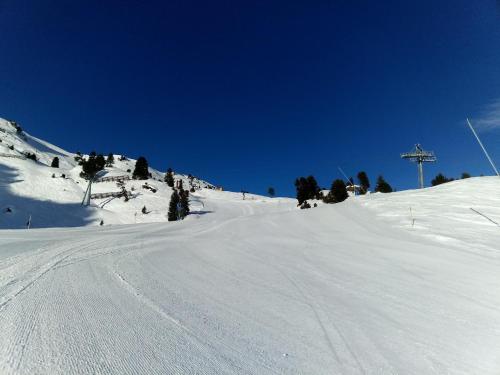 a snow covered slope with a ski lift in the distance at Wieshof in Kaltenbach