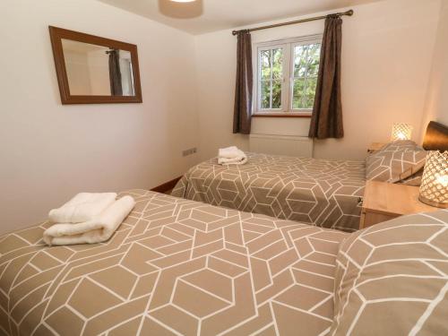 a bedroom with two beds and a mirror at The Baler House in Hayle