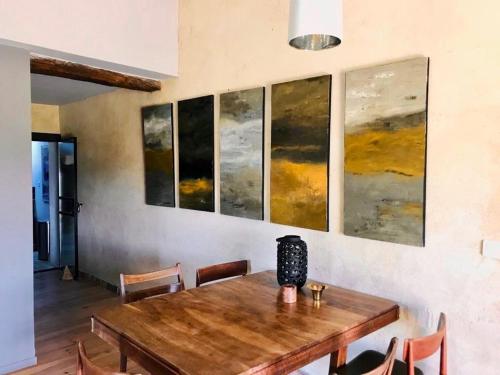 une salle à manger avec une table en bois et des peintures murales dans l'établissement Charming Apartment In The Heart Of Drôme Provence, à Puy-Saint-Martin