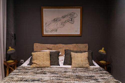 une chambre avec un lit avec un tableau sur le mur dans l'établissement Charming Apartment In The Heart Of Drôme Provence, à Puy-Saint-Martin