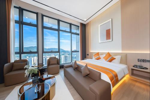 a hotel room with a bed and a couch at Oakwood BLEXUS Apartment Sanya in Sanya