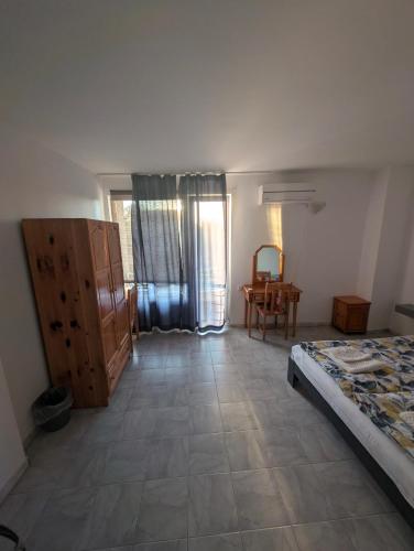a bedroom with a bed and a table in a room at Guesthouse in Chernomorets next to Gradina and Sozopol in Chernomorets