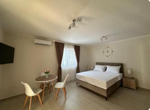 a bedroom with a bed and a table and chairs at Studio apartment with heated pool in Kotor