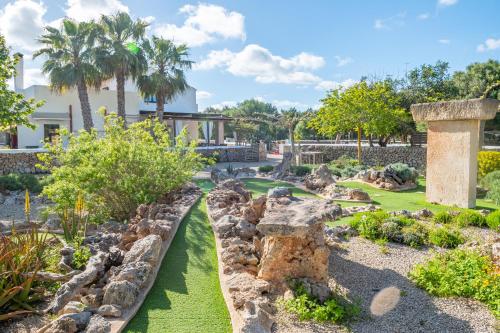 a garden with rocks and trees and a building at Turismo Rural Biniati des Pi in Sant Lluis