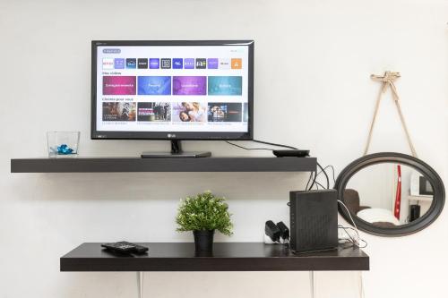 un écran d'ordinateur posé sur une étagère noire dans l'établissement Le Mirabeau - Hypercenter studio - Wifi - Train station, à Aix-en-Provence