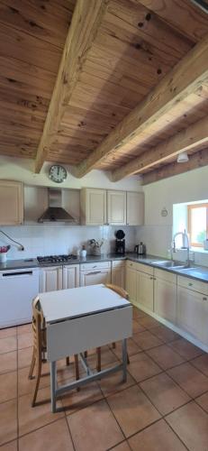 - une grande cuisine avec des appareils blancs et des plafonds en bois dans l'établissement Gentilhomme, à Donzy-le-National