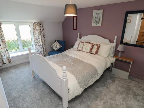 a bedroom with a white bed and a window at Chapel Hill House in Pembroke