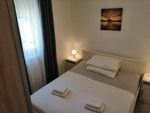 a small white bed with two folded towels on it at Apartmani Mila-Casa Bianca in Medulin