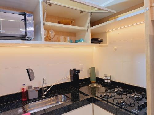 a kitchen counter with a sink and a stove at Studio Luxo, em Anápolis - Perfeito in Anápolis