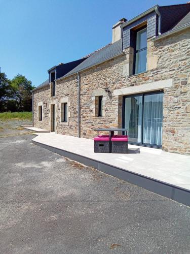 un bâtiment en briques avec un banc devant lui dans l'établissement Magnifique résidence de vacances, à Pluherlin