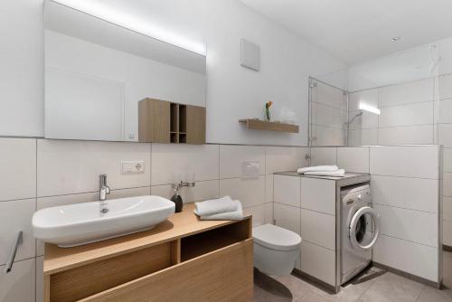 un bagno con lavandino e lavatrice di Ferienwohnung Rebenrain, 80qm a Steinach