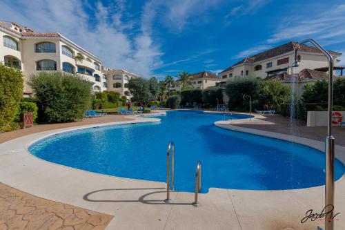 une grande piscine bleue dans un complexe hôtelier dans l'établissement Fantástico Ático Dúplex en Marbella, con vistas al mar y a 300 metros de la playa, à Marbella