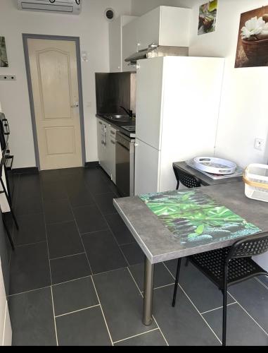 une cuisine avec une table et un réfrigérateur blanc dans l'établissement MARSEILLAN Ville, à Marseillan