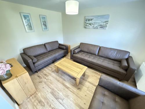 a living room with two couches and a coffee table at Jolly Roger Cottage - Part of the The Bay Filey Holiday Village with pool, gym and direct beach access, pub, restaurant, tennis and meadows walks in Filey