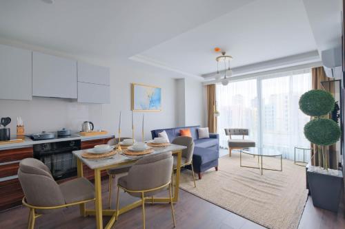 a kitchen and living room with a table and chairs at Modern Furnished Apartments in Istanbul Basaksehir By Iradah Gayrimenkul in Basaksehir