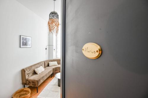 une porte menant à un salon avec un canapé dans l'établissement Chez Marius - Appart 1 ch avec clim - St Charles, à Marseille