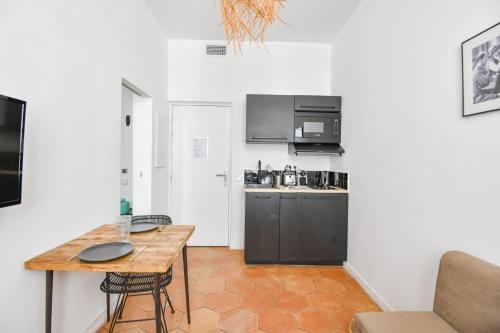 - une petite cuisine avec une table et un comptoir dans l'établissement Chez Marius - Appart 1 ch avec clim - St Charles, à Marseille