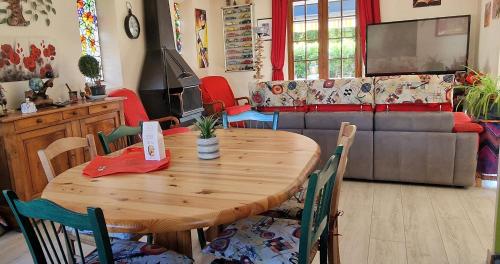 un salon avec une table en bois et un canapé dans l'établissement Très belle Maison languedocienne à 15 mn de la mer avec trois belles chambres, 2 coins repas extérieurs avec barbecue et bain de soleil, à Lunel