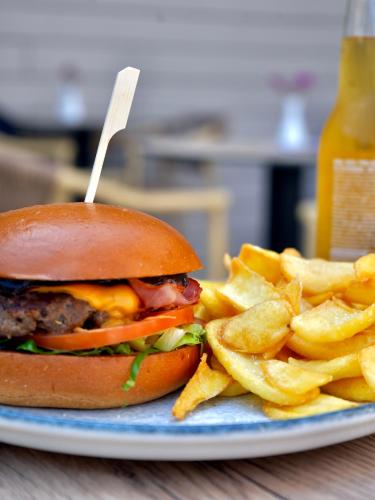 a hamburger and french fries on a plate at Telesilla Hotel in Kontokali