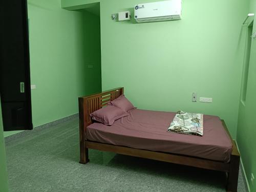 a small bed with purple sheets and pillows in a room at La Rasamb sejour villa in Kottakupam