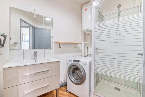 une salle de bain blanche avec une machine à laver et un lavabo dans l'établissement Le central - Rue du mail, à Angers