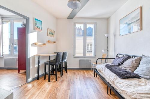 une chambre avec un lit, une table et des chaises dans l'établissement Le central - Rue du mail, à Angers